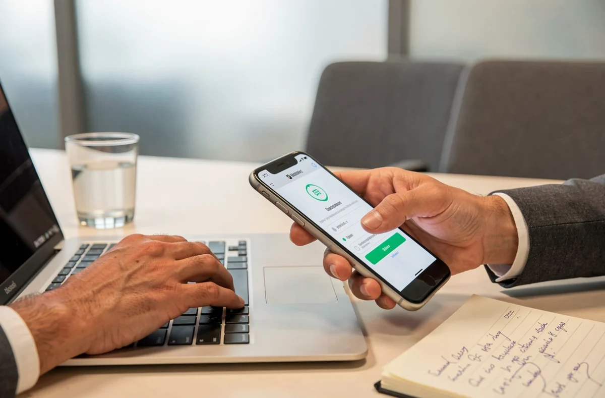 Mains utilisant un smartphone pour récupérer un code d'authentification lors d'une réinitialisation de mot de passe