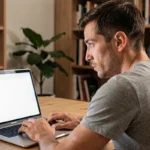 Homme confus regardant un écran d'ordinateur affichant une page about:blank dans un navigateur