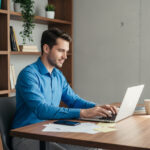 Jeune homme concentré travaillant sur son ordinateur dans un bureau moderne